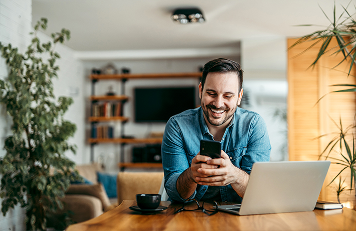 A man looking at his cell phone in his home